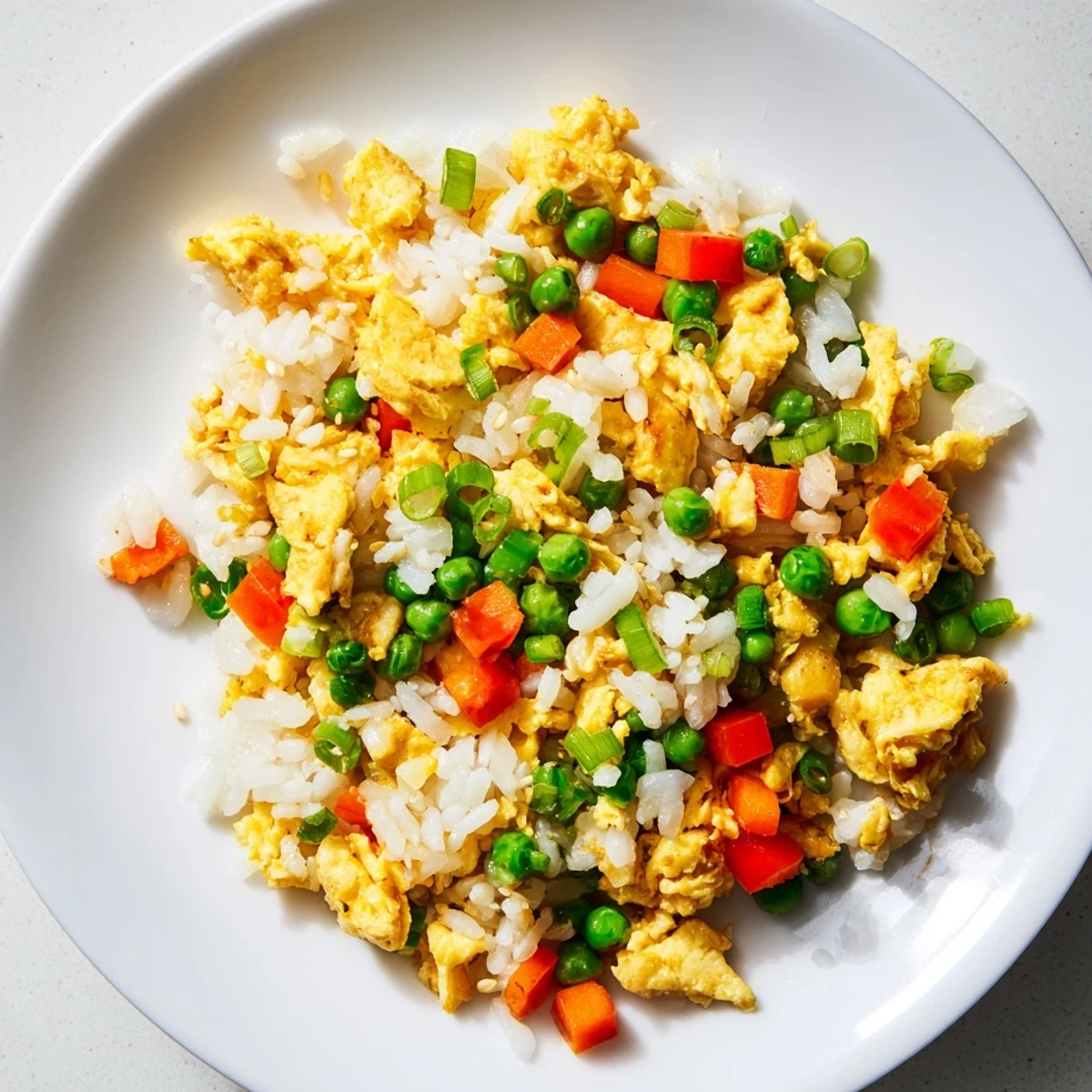 Fluffy scrambled eggs and vibrant vegetables tossed with fluffy rice and savory soy sauce in this classic Egg Fried Rice Classic.  