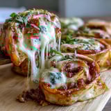 Spiral-cut Tortilla Pizza Rolls on a wooden board with pepperoni and bell peppers, ready to be dipped in warm marinara.