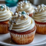 Adorable mini vanilla cupcakes decorated with delicate buttercream swirls and fondant rosary toppers, ideal for First Communion celebrations.