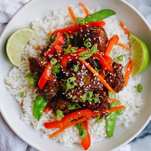 Sesame Ginger Rice Bowl, vibrant and steaming, featuring tender chicken and colorful stir-fried vegetables.