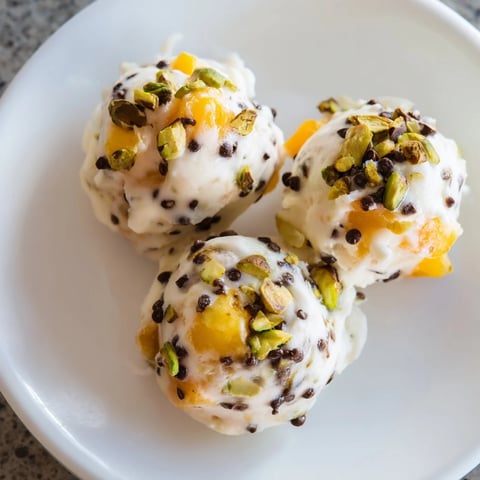Golden, creamy Frozen Peach Yogurt Bites, topped with dark chocolate chips, ready to eat this summer afternoon.