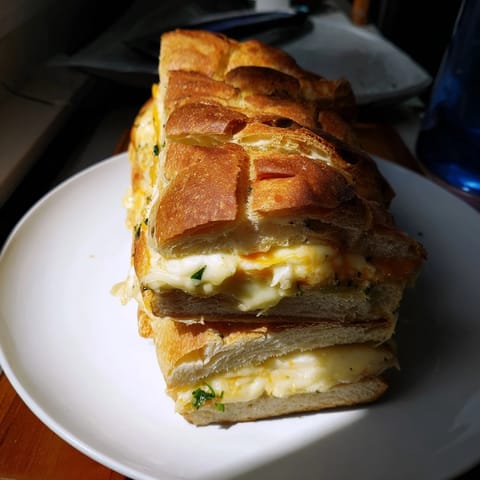 Melted cheese oozes from a delicious Cheesy Garlic Pull-Apart Bread, perfect as a shareable appetizer.