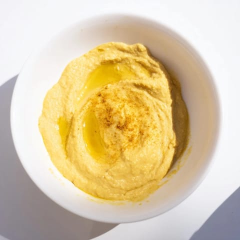 Spoonful of Chickpea Curry Paste spread on warm naan, garnished with fresh cilantro and a lemon wedge for brightness.