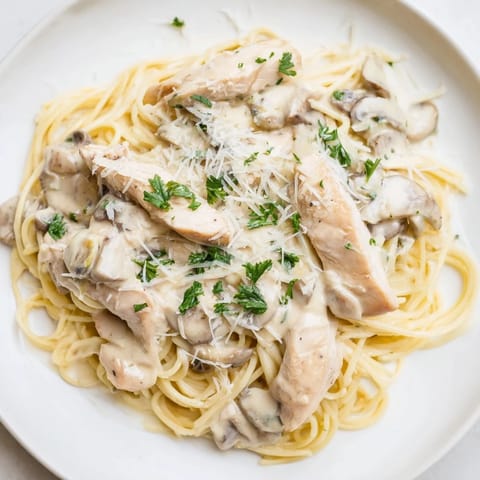 Savory Creamy Mushroom Chicken Spaghettini served in a shallow bowl, featuring tender chicken and mushrooms in a light, velvety cream sauce.