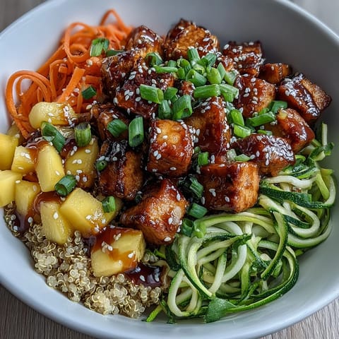 Vibrant Easy Teriyaki Quinoa Bowl with crispy baked tofu, spiralized zucchini and carrots, fresh mango, and a glossy teriyaki glaze.  