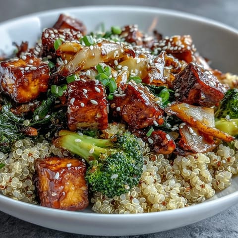 A vibrant bowl of quinoa vegetable teriyaki, garnished with sesame seeds and fresh green onions for a wholesome meal.