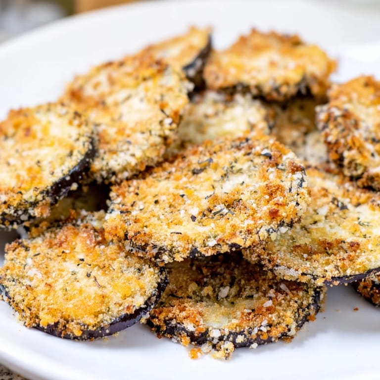 Thin, golden rounds of Eggplant Parmesan Chips, offering a delightful bite of Italian-American comfort food.