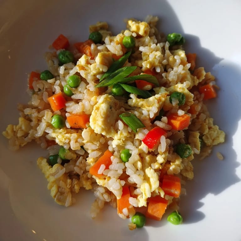 Close-up view of golden Egg Fried Rice Classic with peas, carrots, and tender egg ribbons, ready to enjoy for a quick weeknight dinner.