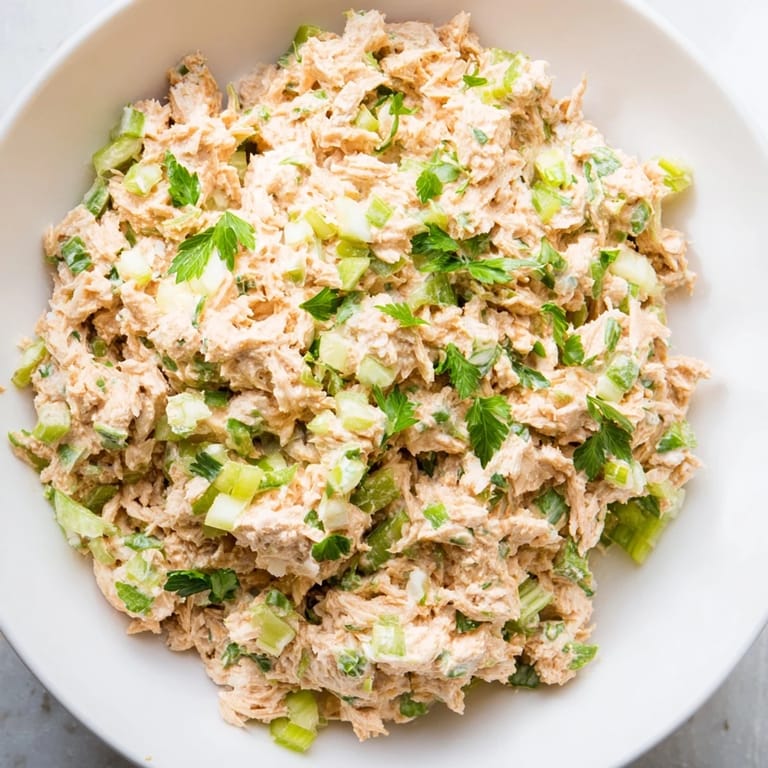 Chilled bowl of protein-packed Spicy Zesty Tuna Salad with crisp celery and scallions, perfect for lettuce wraps or crackers.