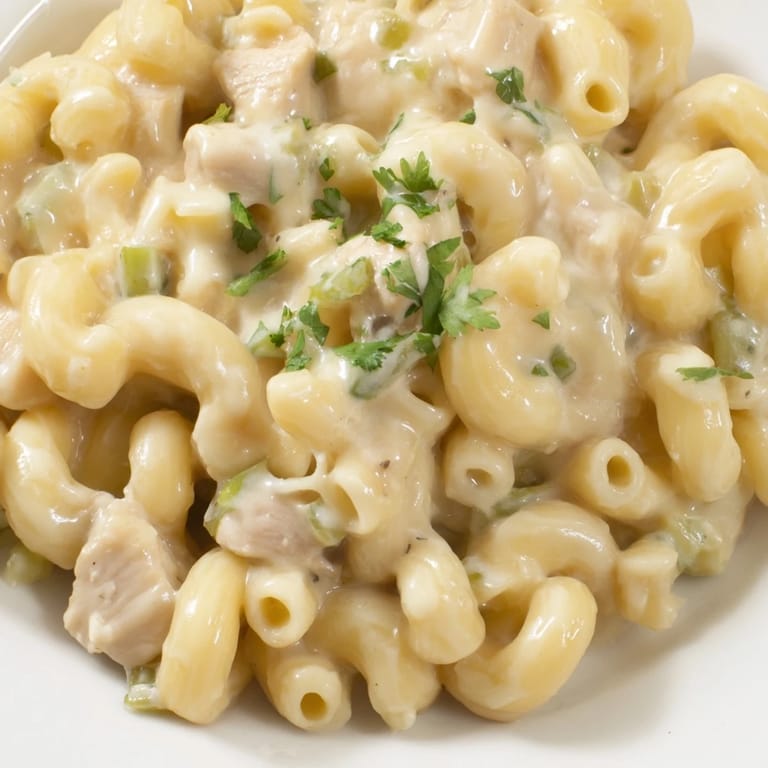 Close-up of Green Chili Chicken Mac showing juicy chicken pieces and gooey cheese sauce clinging to small pasta shells.