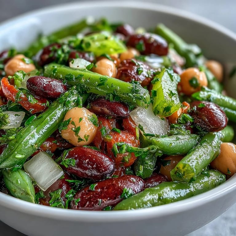 Chilled Three-Bean Salad topped with fresh parsley and diced red onion, perfect for a healthy picnic side dish or backyard BBQ.  