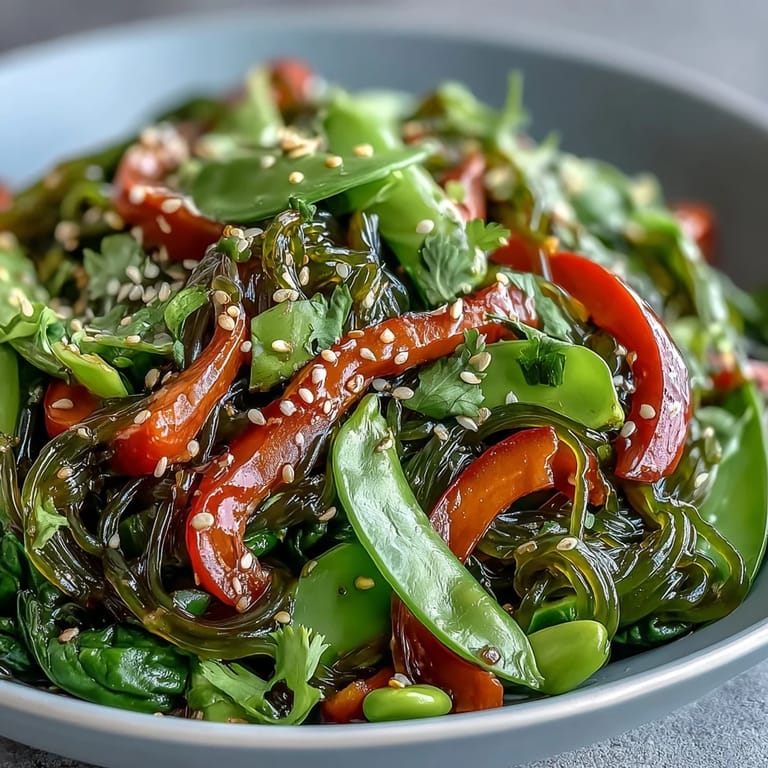 A close-up of Kelp Noodle Stir-Fry featuring colorful bell peppers, snap peas, and carrots tossed in a savory sesame glaze.  