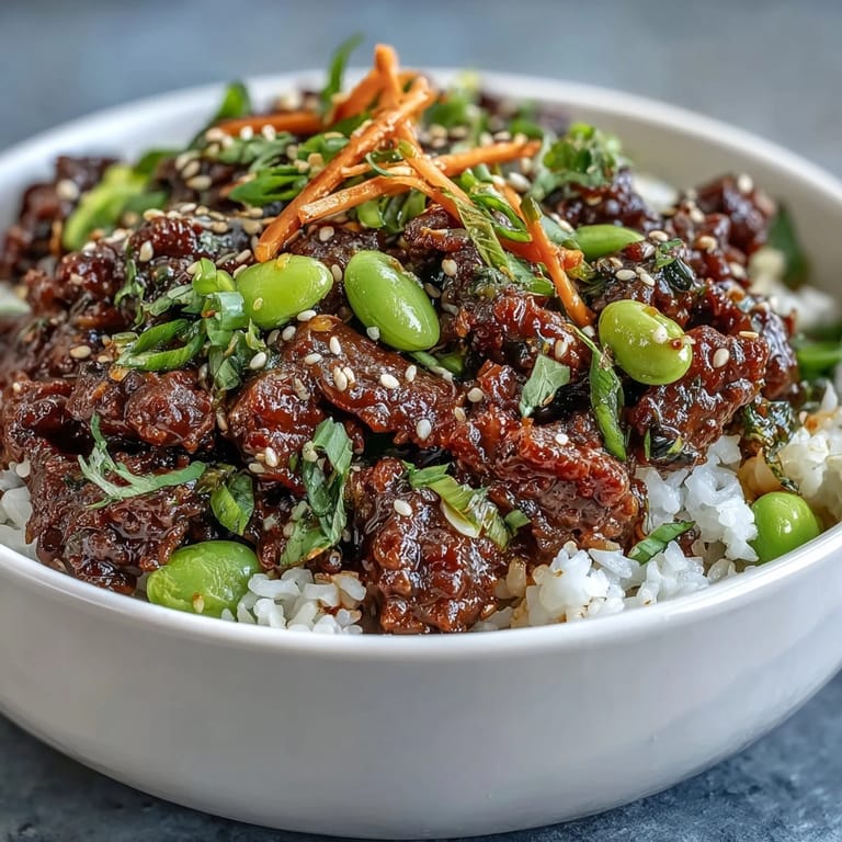Ready-to-eat Korean Ground Beef Bowl with colorful veggies, ground beef, and sesame seeds on white rice.