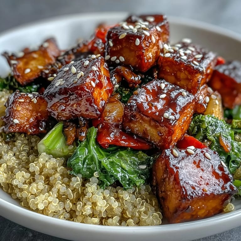 Serving suggestion for a quinoa vegetable teriyaki bowl with tender-crisp broccoli, carrots, and snap peas on a dark plate.
